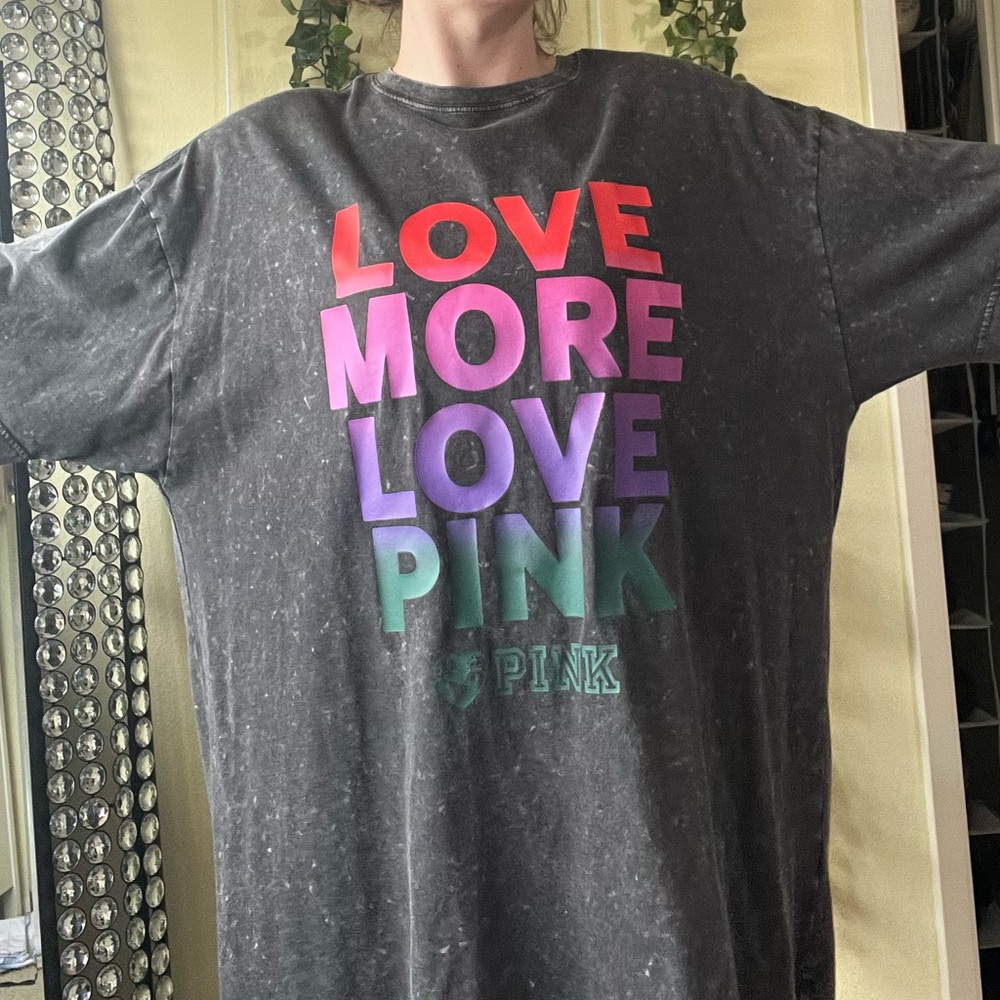 Pink one sized tee shirt. Gray with rainbow lettering.